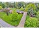 Aerial view of a well-maintained brick home with a long driveway, lush green lawns, and mature trees at 10559 Rolling Springs Dr, Indianapolis, IN 46234