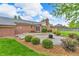 Beautiful backyard featuring a brick home, outdoor fireplace, and manicured landscaping at 10559 Rolling Springs Dr, Indianapolis, IN 46234