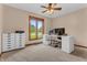 Bright office space featuring a white desk, rolling file cabinet, and a large window with a green outdoor view at 10559 Rolling Springs Dr, Indianapolis, IN 46234