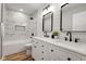 Elegant bathroom featuring marble tiles, dual vanity with framed mirrors, and modern black faucets at 1147 Kelsneland Dr, Avon, IN 46123
