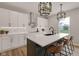 Modern kitchen with white cabinets, marble countertops, and a dark contrasting island with counter seating at 1147 Kelsneland Dr, Avon, IN 46123