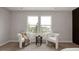 Cozy sitting area featuring neutral carpet, two white chairs, and bright natural light at 1147 Kelsneland Dr, Avon, IN 46123