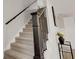 Elegant staircase with carpeted steps, a sleek black railing, and well-lit design, creating a welcoming entrance at 1147 Kelsneland Dr, Avon, IN 46123