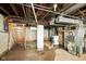 Unfinished basement with old furnace, water heater, and concrete flooring at 1235 N Grant Ave, Indianapolis, IN 46201