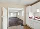 A view from the kitchen of the open carpeted living room with windows and a doorway at 1235 N Grant Ave, Indianapolis, IN 46201