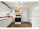 Modest kitchen with laminate floors, white appliances, and adjacent white door at 1235 N Grant Ave, Indianapolis, IN 46201