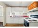 Functional kitchen with white cabinets, laminate floors, and white appliances at 1235 N Grant Ave, Indianapolis, IN 46201