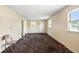 Empty living room featuring natural light from windows and neutral carpet at 1235 N Grant Ave, Indianapolis, IN 46201