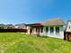 Home exterior with a backyard featuring a green lawn, wood fence, and pergola-covered stone patio at 12551 Hawks Landing Dr, Fishers, IN 46037