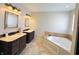 Bathroom with double vanities, corner tub and neutral tones for a clean, elegant look at 12551 Hawks Landing Dr, Fishers, IN 46037