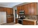 Kitchen features wood cabinets, stainless appliances, stone backsplash, and ample counter space at 12551 Hawks Landing Dr, Fishers, IN 46037