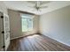 Bright office featuring hardwood floors, a ceiling fan, and a large window, creating a comfortable workspace at 12551 Hawks Landing Dr, Fishers, IN 46037