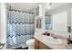 Clean bathroom with a toilet, vanity, and shower with a colorful patterned curtain at 12984 Shandon Ln, Fishers, IN 46038