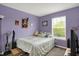 Cozy bedroom featuring soft lavender walls, a comfortable bed, and bright natural light from the window at 12984 Shandon Ln, Fishers, IN 46038