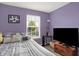 Bright bedroom features a comfortable bed, a window view, and a dark flatscreen TV at 12984 Shandon Ln, Fishers, IN 46038