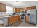 Modern kitchen with stainless steel appliances, wood cabinetry and bright, natural light at 12984 Shandon Ln, Fishers, IN 46038