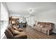 Open concept living room featuring wood floors, a large sofa set, and an adjacent dining area and kitchen at 12984 Shandon Ln, Fishers, IN 46038
