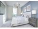 Well-lit bedroom with neutral walls, large window, light fixture, and modern furnishings and decor at 13324 Roundtop Rd, Noblesville, IN 46060