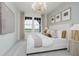 Bright bedroom with a large window overlooking greenery and a stylish chandelier at 13324 Roundtop Rd, Noblesville, IN 46060