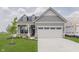 Charming single-Gathering home with gray siding, a two-car garage and a well manicured front yard at 13324 Roundtop Rd, Noblesville, IN 46060