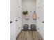 Hallway between two doors with light brown flooring and woven grey cube chairs at 13324 Roundtop Rd, Noblesville, IN 46060