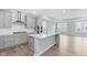 Modern kitchen featuring gray cabinets, a large island, stainless steel appliances, and hardwood floors at 13324 Roundtop Rd, Noblesville, IN 46060