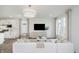 Open-concept living space with white sofa, view of kitchen, large windows, and modern decor at 13324 Roundtop Rd, Noblesville, IN 46060