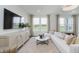 Cozy living room featuring a plush sofa, large windows, and contemporary furnishings at 13324 Roundtop Rd, Noblesville, IN 46060