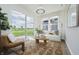 Bright sunroom with large windows offers serene views and comfortable seating, perfect for relaxation and enjoying the outdoors at 13324 Roundtop Rd, Noblesville, IN 46060