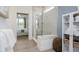Bright bathroom with glass door shower and doorway to bedroom in neutral color palette at 13355 Seven Springs Ln, Noblesville, IN 46060
