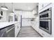 Well-equipped kitchen with stainless steel appliances, including double ovens, and sleek white cabinetry at 13355 Seven Springs Ln, Noblesville, IN 46060