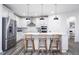 Bright, stylish kitchen featuring a large island, stainless steel appliances, and modern pendant lighting at 13355 Seven Springs Ln, Noblesville, IN 46060