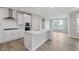 Bright kitchen features white cabinets, stainless steel appliances, a large island, and hardwood floors at 13355 Seven Springs Ln, Noblesville, IN 46060