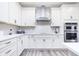 Modern kitchen showcasing stainless steel appliances, white cabinetry, and a stylish range hood at 13355 Seven Springs Ln, Noblesville, IN 46060