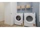 Convenient laundry area with modern washer and dryer units and shelving for storage at 13355 Seven Springs Ln, Noblesville, IN 46060