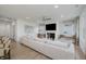 Spacious living room with a plush white sectional sofa, fireplace and large windows providing natural light at 13355 Seven Springs Ln, Noblesville, IN 46060