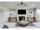 Bright living room showcasing a white fireplace with television, a ceiling fan and windows at 13355 Seven Springs Ln, Noblesville, IN 46060