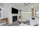 Cozy living room with a fireplace, ceiling fan, and plenty of natural light at 13355 Seven Springs Ln, Noblesville, IN 46060