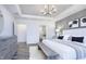 Elegant main bedroom featuring a decorative wall panel, modern chandelier, and a tray ceiling at 13355 Seven Springs Ln, Noblesville, IN 46060