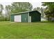 Spacious, green storage shed with garage door and standard door at 1425 E Us Highway 40, Clayton, IN 46118
