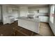 A kitchen is shown with white cabinets, gray countertops, and a spacious island with a stainless steel sink at 1428 Aster Dr, Shelbyville, IN 46176