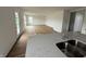 A well-lit living room is displayed with multiple windows, a glass door, and temporary floor covering at 1428 Aster Dr, Shelbyville, IN 46176