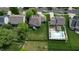 A residential backyard with green lawn, patio furniture, pool, landscaping, and a fence with trees is showcased at 18247 Kinder Oak Dr, Noblesville, IN 46062