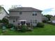 Backyard showing a patio with umbrella, seating, firepit, green lawn and landscaping, and two story house at 18247 Kinder Oak Dr, Noblesville, IN 46062