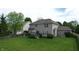 A backyard featuring a lush lawn, trees, a patio seating area, and a two-story home is captured at 18247 Kinder Oak Dr, Noblesville, IN 46062