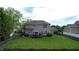 Backyard featuring a spacious green lawn, patio area, firepit, fence, mature trees, and two story house at 18247 Kinder Oak Dr, Noblesville, IN 46062