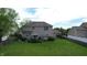 View of a backyard featuring a patio, firepit, green lawn, trees, and a two-story house at 18247 Kinder Oak Dr, Noblesville, IN 46062