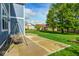 View of the patio and backyard, with green grass and trees and homes in the background at 18820 Wychwood Pl, Noblesville, IN 46062