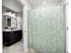 Well-lit bathroom featuring a dark vanity, elegant mirror, and a shower with a stylish floral curtain at 18820 Wychwood Pl, Noblesville, IN 46062
