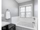 Clean bathroom highlighting a soaking tub with subway tile surround and a window view at 18820 Wychwood Pl, Noblesville, IN 46062